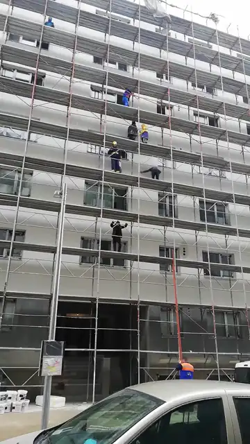 Echipă la lucru pe schela unui bloc, termosistem în execuție
